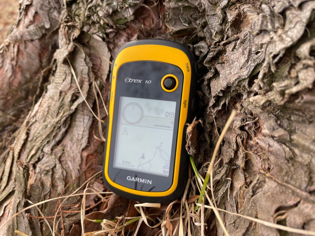a GPS unit sitting against a tree